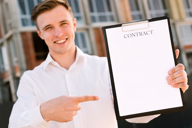 Foto gratuita tiro medio hombre feliz apuntando al contrato