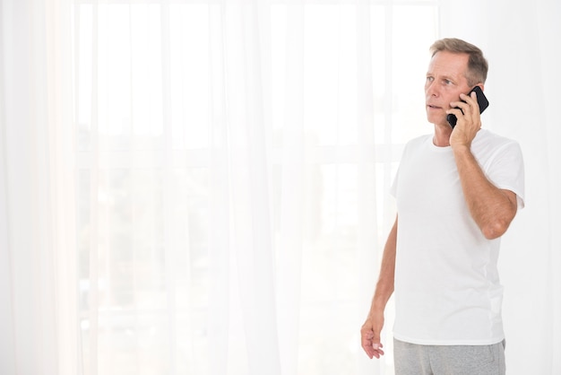 Tiro medio hombre hablando por teléfono