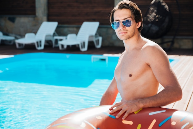 Tiro medio hombre joven en la piscina.