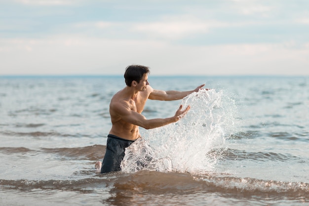 Tiro medio hombre jugando en el agua.