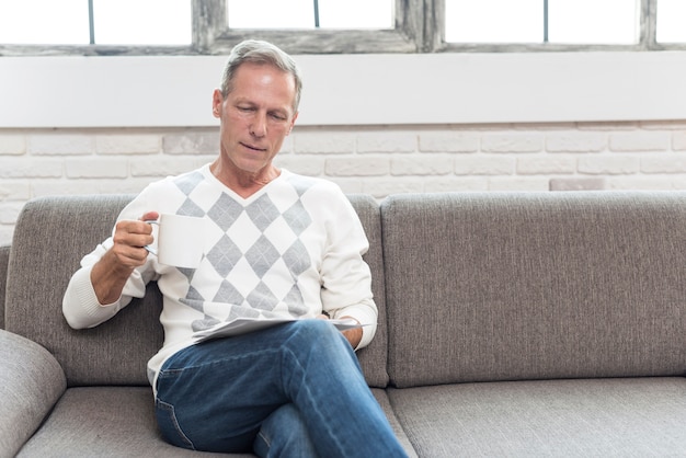 Foto gratuita tiro medio hombre leyendo en el sofá