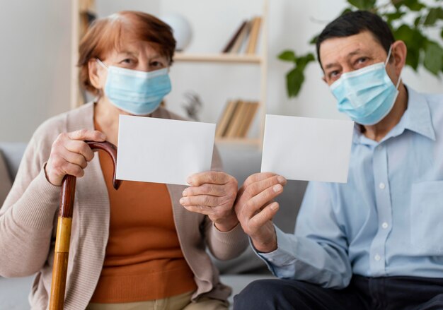 Tiro medio hombre y mujer sosteniendo tarjetas