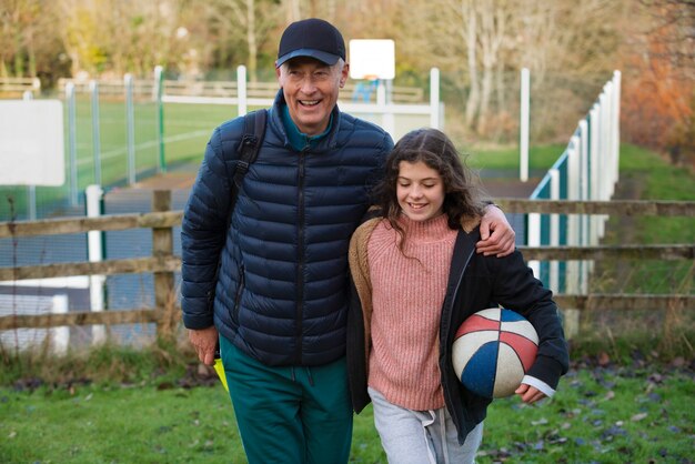 Tiro medio hombre y niña con pelota