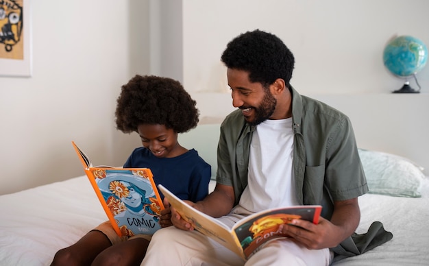 Foto gratuita tiro medio hombre y niño leyendo cómics en casa