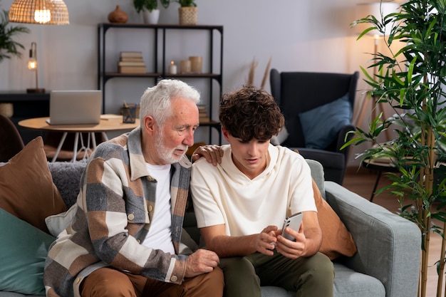 Tiro medio hombre y niño con teléfono.