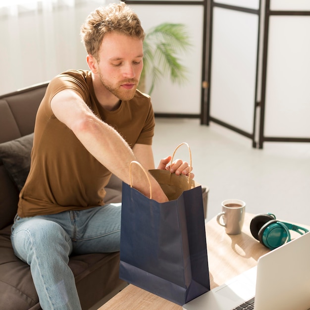 Tiro medio hombre revisando bolsa de papel