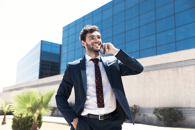 Tiro medio hombre sonriente hablando por teléfono