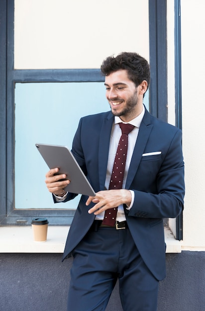 Foto gratuita tiro medio hombre sonriente mirando tableta