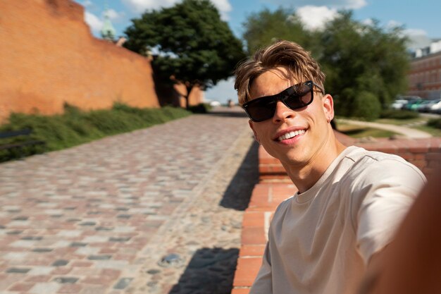 Tiro medio hombre sonriente posando al aire libre