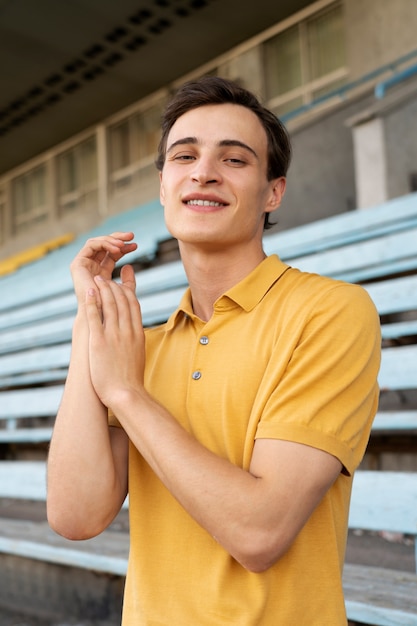 Foto gratuita tiro medio hombre sonriente posando al aire libre