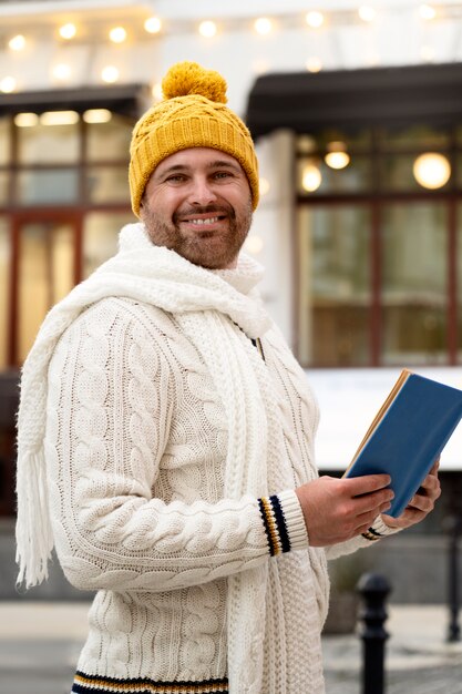 Tiro medio hombre sonriente sosteniendo libro