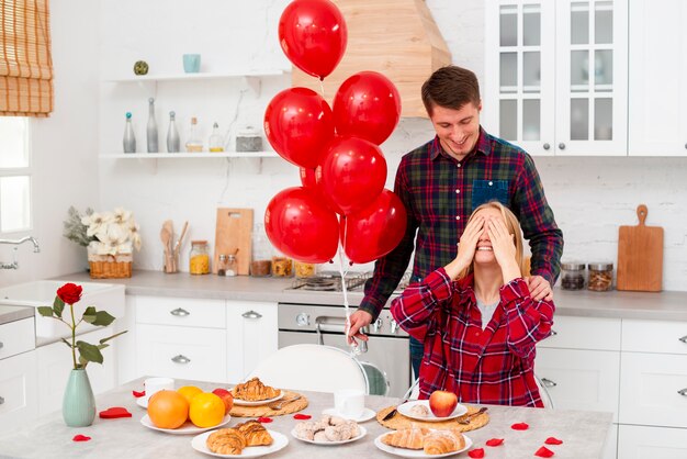 Tiro medio hombre sorprendente mujer con globos