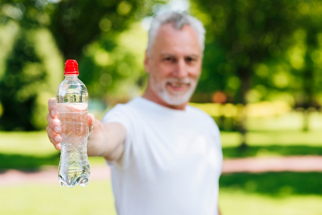 Tiro medio hombre sosteniendo una botella de agua