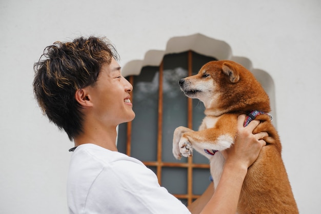 Foto gratuita tiro medio hombre sosteniendo lindo perro