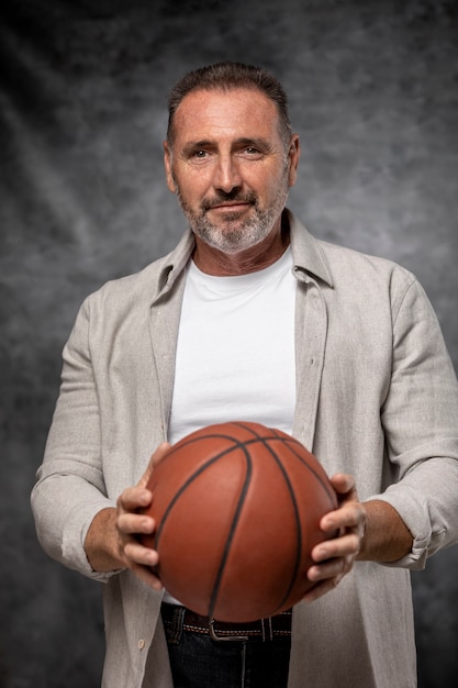 Tiro medio hombre sujetando la pelota de baloncesto