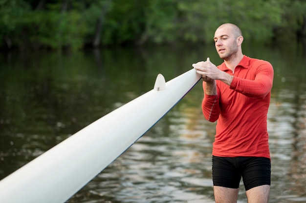 Foto gratuita tiro medio, hombre, tenencia, canoa