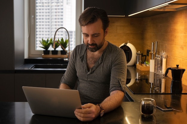 Foto gratuita tiro medio hombre trabajando en la computadora portátil