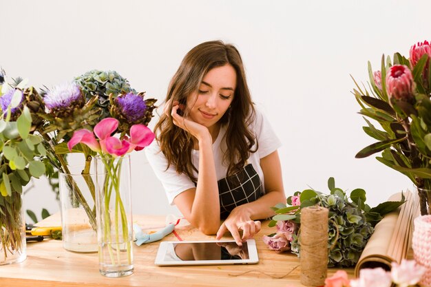 Tiro medio joven florista con tableta