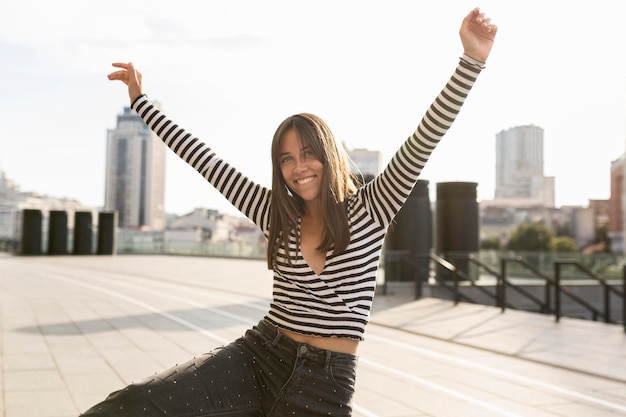 Tiro medio linda mujer sonriente posando en la luz del sol