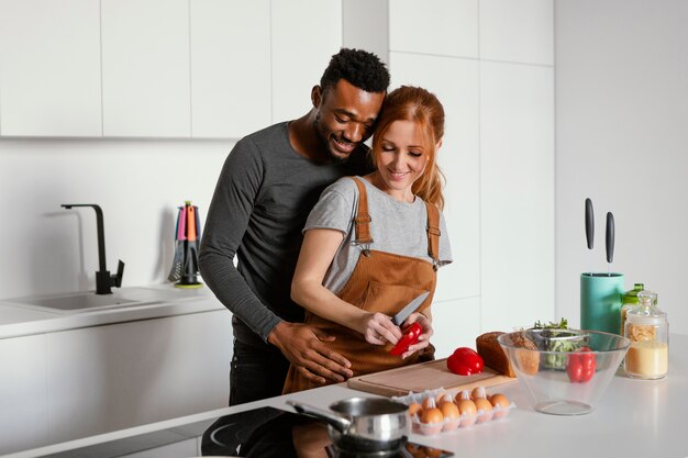 Tiro medio linda pareja cocinando