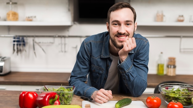 Tiro medio macho sonriendo en la cocina