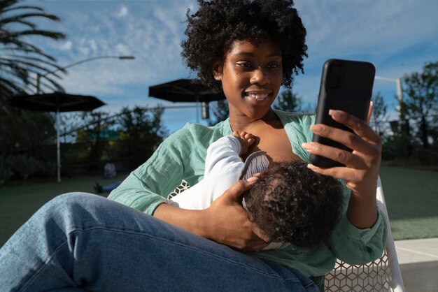 Tiro medio madre amamantando al bebé al aire libre