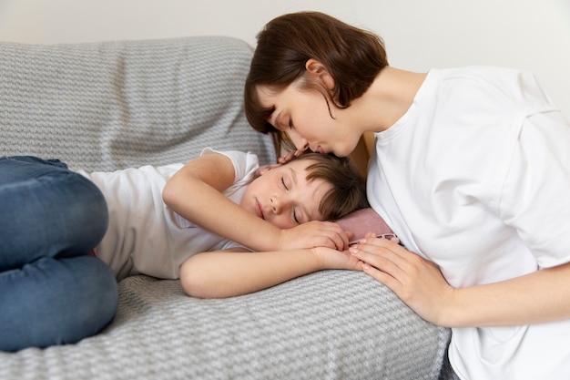 Tiro medio madre besando a niña en la cabeza.