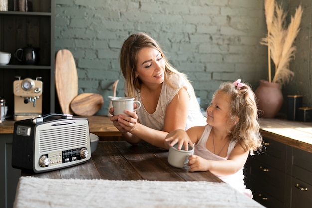 Tiro medio, madre e hija sosteniendo copas