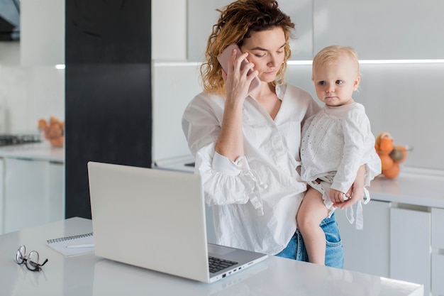 Tiro medio madre hablando por teléfono