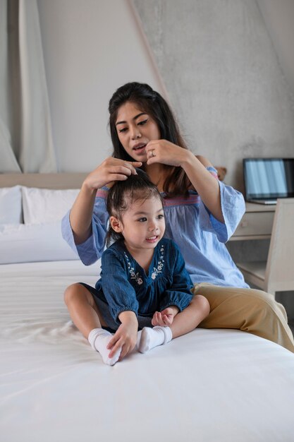 Tiro medio madre y niña en la cama