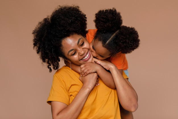 Foto gratuita tiro medio madre y niña posando en estudio