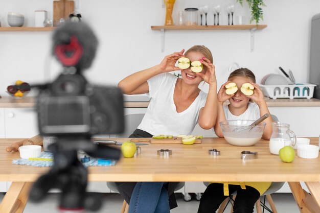 Tiro medio madre y niña sosteniendo manzanas