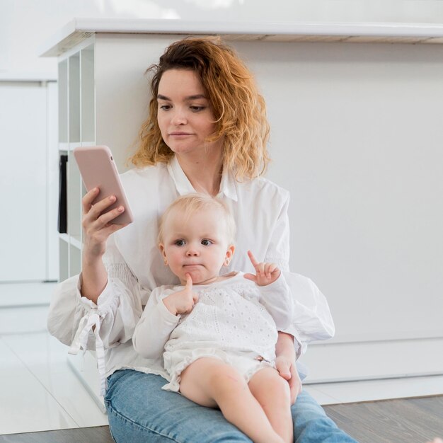 Tiro medio madre con niño en el piso