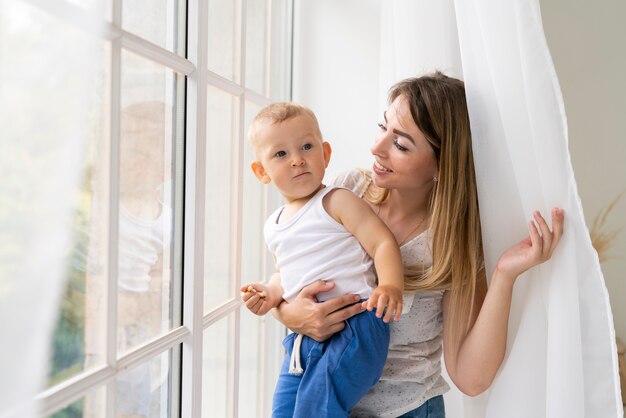 Tiro medio madre sonriendo a su hijo