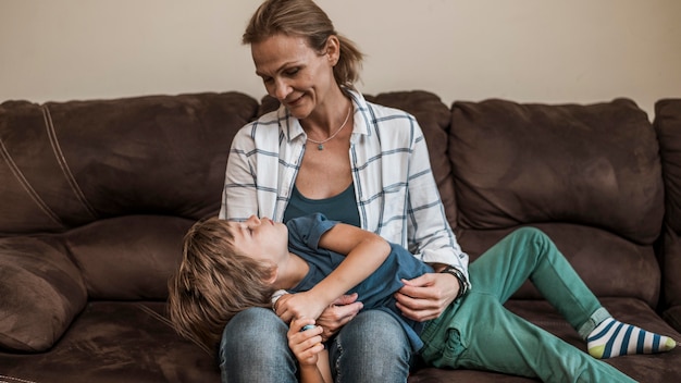 Foto gratuita tiro medio madre sosteniendo niño en el interior