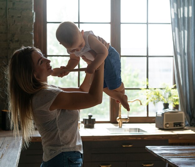 Tiro medio, madre sosteniendo a su bebé