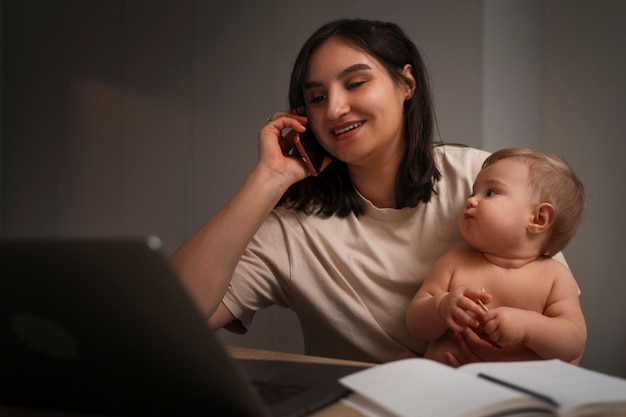 Tiro medio madre trabajando con bebé