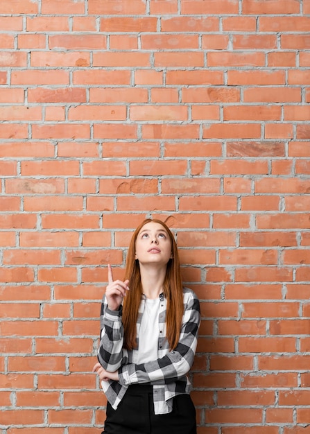 Foto gratuita tiro medio mujer apuntando hacia arriba