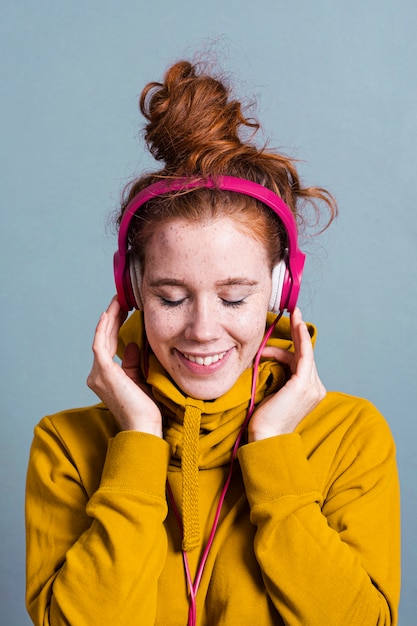 Tiro medio mujer con auriculares y amplia sonrisa