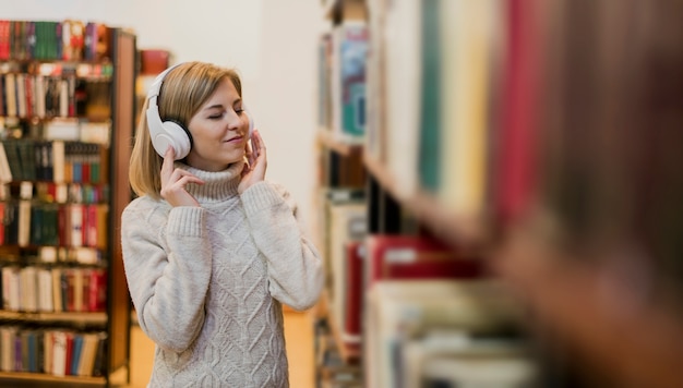 Tiro medio mujer con auriculares en librería