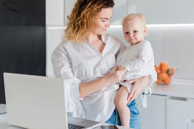 Tiro medio mujer con bebé pequeño