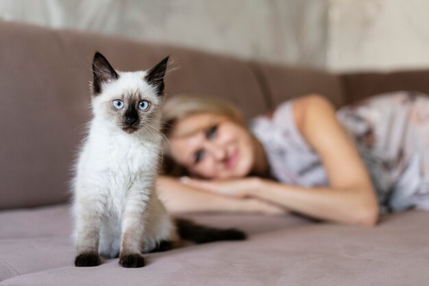 Tiro medio mujer borrosa y lindo gato