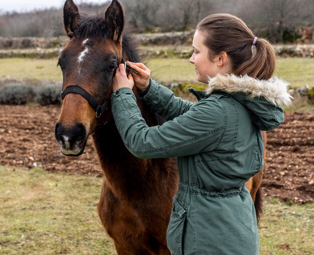 Tiro medio mujer y caballo al aire libre