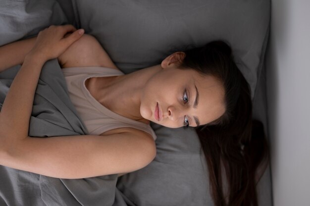 Tiro medio mujer cansada en la cama