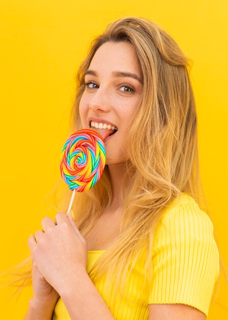 Tiro medio mujer comiendo paleta