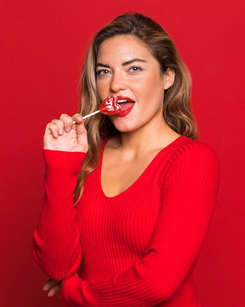 Tiro medio mujer comiendo piruleta