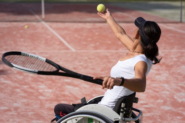 Tiro medio mujer con discapacidad sosteniendo la bola