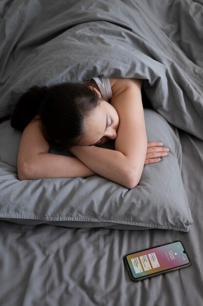 Tiro medio mujer durmiendo con teléfono