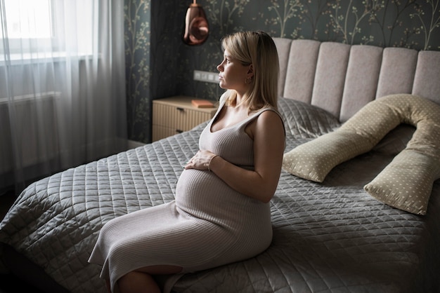 Tiro medio mujer embarazada sentada