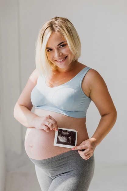 Tiro medio mujer embarazada sosteniendo un ultrasonido